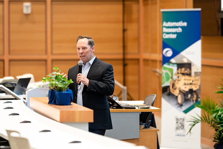 Michael Cadieux, GVSC director, delivers a message to attendees in an event space at the 32nd Automotive Research Center review.