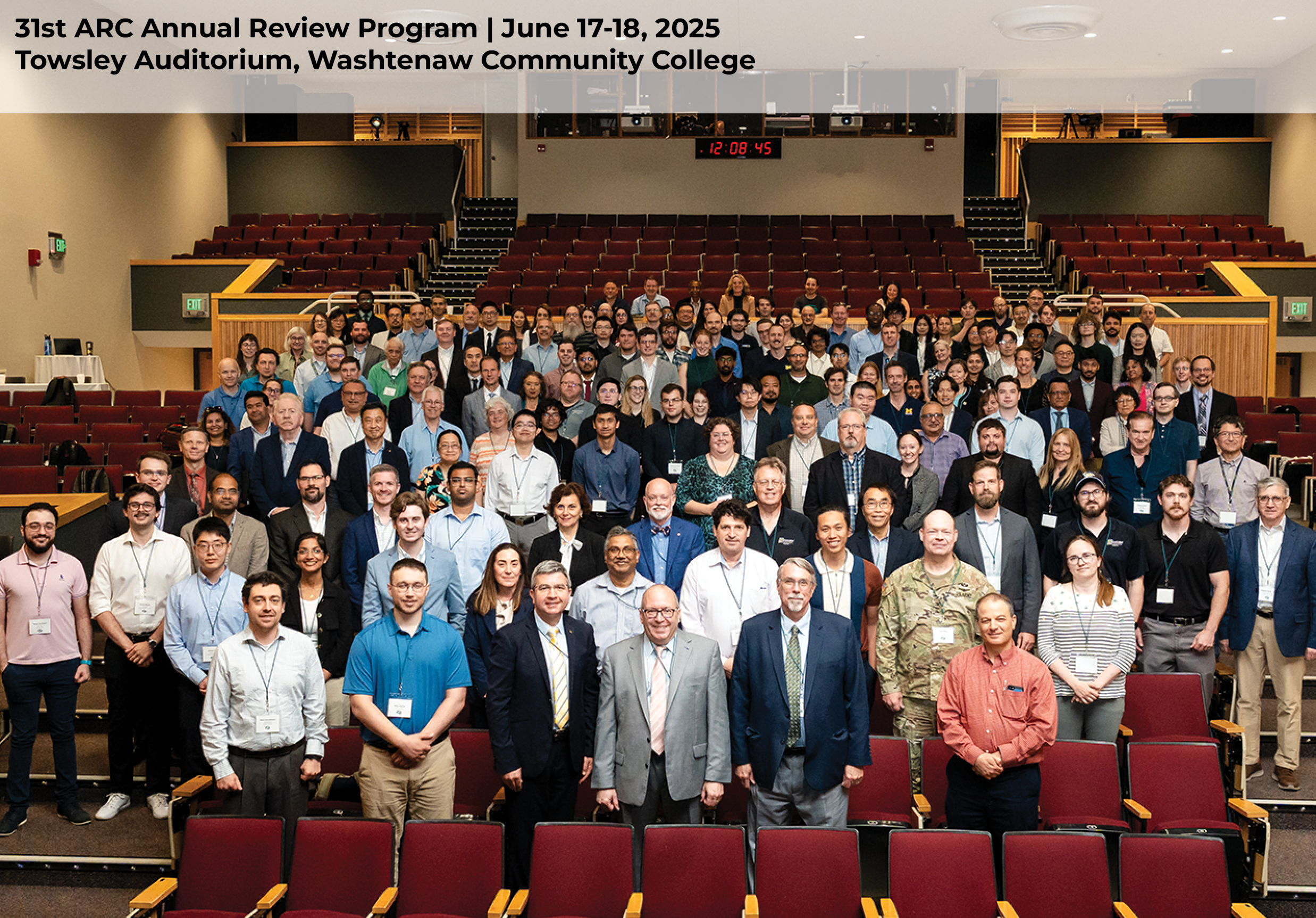  Group photo from 31st ARC Annual Review, taken in a large auditorium with over 150 people total. The group is in the auditorium seats, looking up at the photographer. 