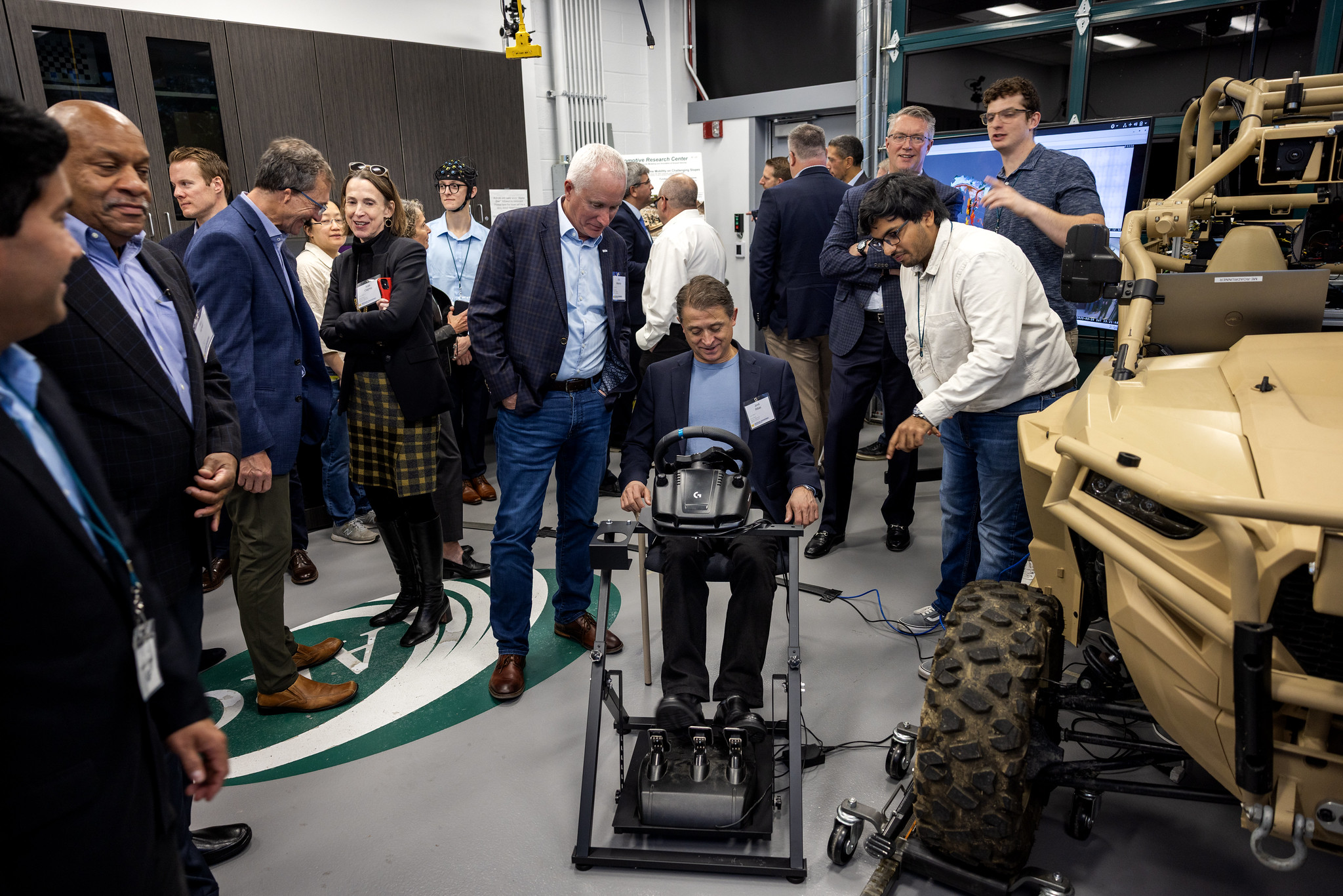  Jordi Ribas sitting in chair with hands on a steering wheel and feet on gas and brake pedals to participate in a live demonstration of vehicle simulation. 